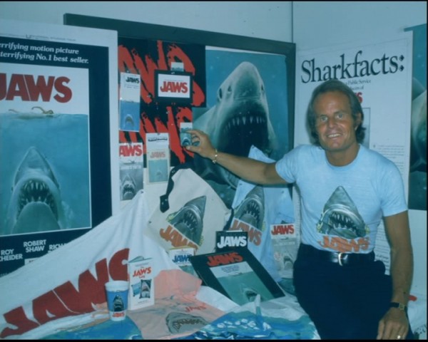 El productor Richard D. Zanuck junto a una muestra del merchandising de Tiburón
